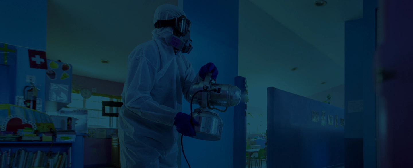 worker sanitizing the classroom